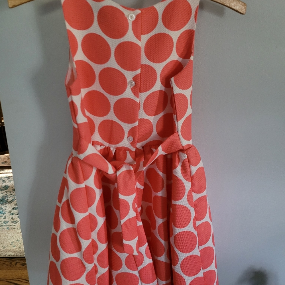 fun,  sleeveless dress,  large coral polka dots on a cream background. ties